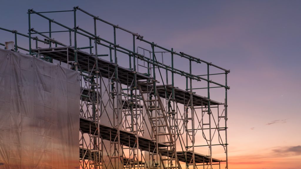 Construction,Site,With,Scaffold,Tower,And,Building,With,Sunset,Background,scaffolding